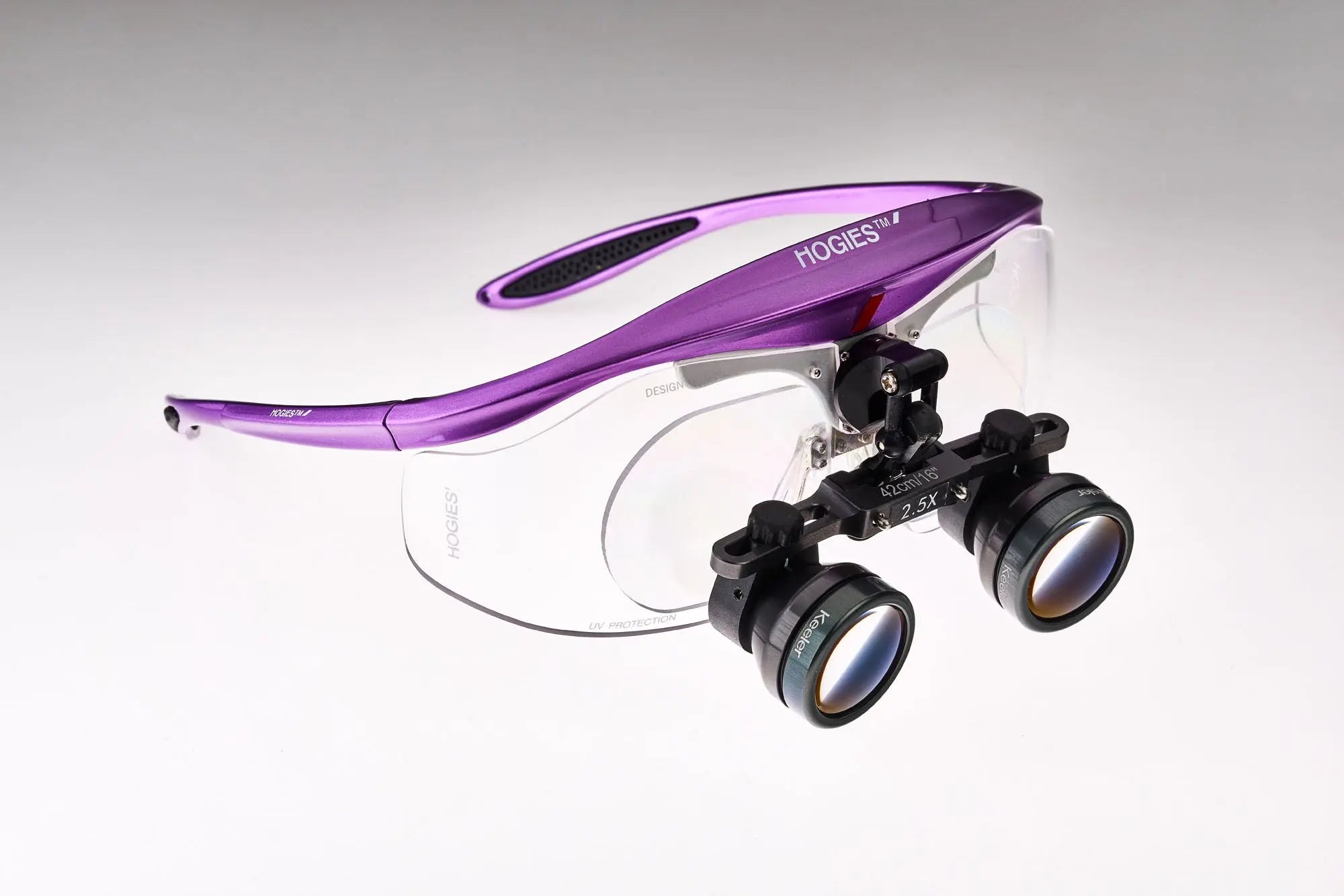 Hogies 2.5x flip-up dental loupes in metallic purple, fitted with a prescription lens carrier on the magnetic frame platform
